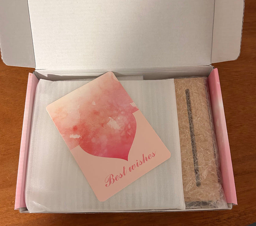 Product packaging with a card and a small item on a wooden surface